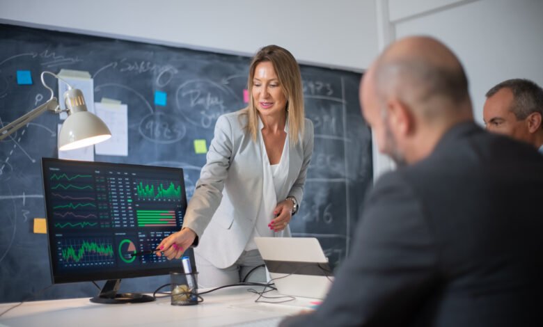 Profissionais analisando indicadores financeiros em painel com gráficos durante reunião de análise de crédito baseada em Open Finance e inteligência de dados.
