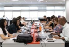equipe de uma empresa trabalhando em um escritório moderno, representando os desafios de reorganização das jornadas de trabalho.