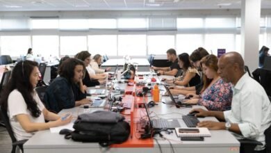 equipe de uma empresa trabalhando em um escritório moderno, representando os desafios de reorganização das jornadas de trabalho.