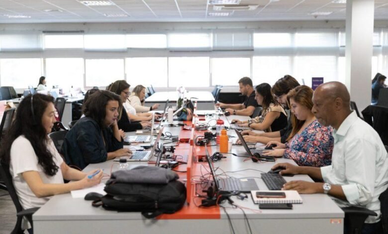 equipe de uma empresa trabalhando em um escritório moderno, representando os desafios de reorganização das jornadas de trabalho.